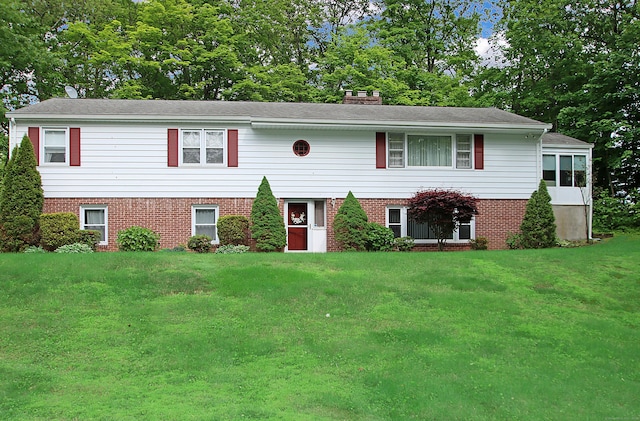 202 Wilson Rd, Orange, CT 06477 - view of front of house with a front yard, brick siding, a chimney, and view of wooded area
