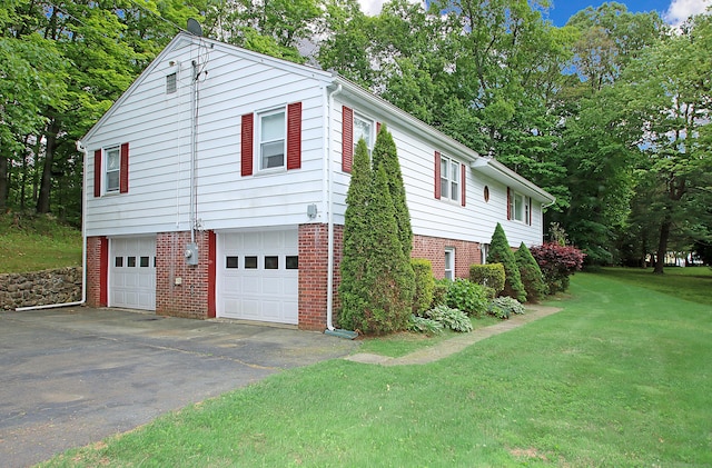 202 Wilson Rd, Orange, CT 06477 - view of side of home with brick siding, a garage, driveway, and a yard