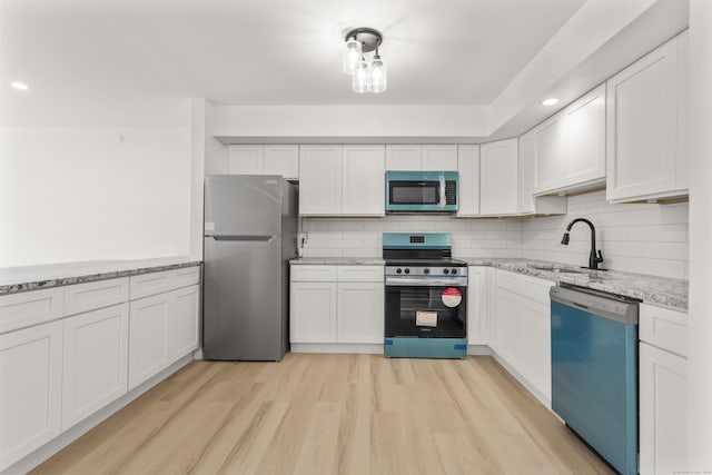 79 Claudia Dr Apt 254, West Haven, CT 06516 - kitchen with stainless steel appliances, a sink, light wood-type flooring, light stone countertops, and recessed lighting