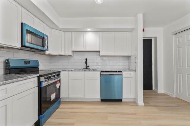 79 Claudia Dr Apt 254, West Haven, CT 06516 - kitchen with appliances with stainless steel finishes, a sink, white cabinetry, and tasteful backsplash