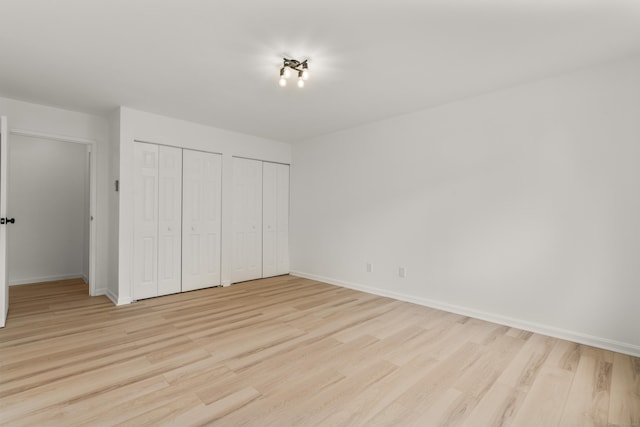 79 Claudia Dr Apt 254, West Haven, CT 06516 - unfurnished bedroom featuring multiple closets, light wood-style flooring, and baseboards