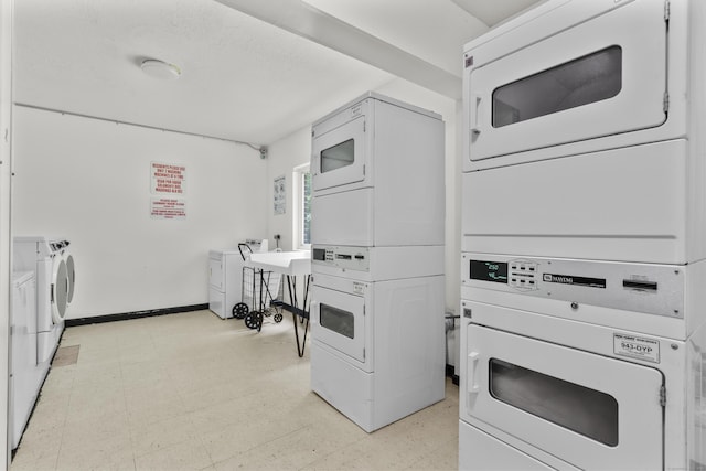 79 Claudia Dr Apt 254, West Haven, CT 06516 - community laundry featuring stacked washer / dryer, light flooring, and baseboards