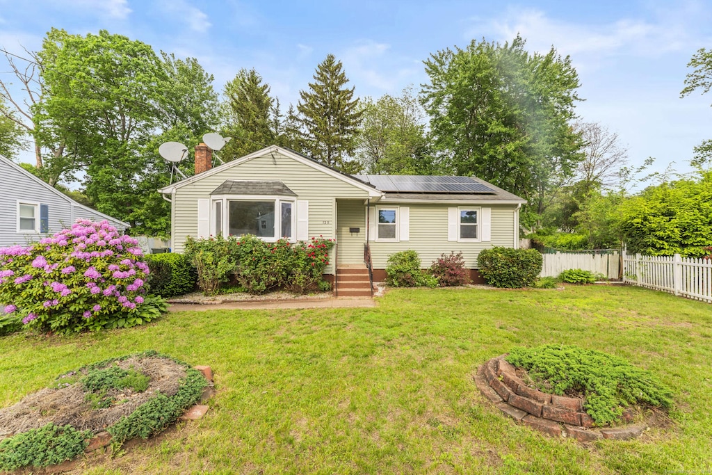 130 Jefferson Ln, East Hartford, CT 06118 - view of front of house with roof mounted solar panels and a chimney
