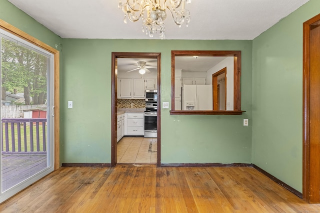 130 Jefferson Ln, East Hartford, CT 06118 - unfurnished dining area with a chandelier, wood-type flooring, baseboards, and a ceiling fan