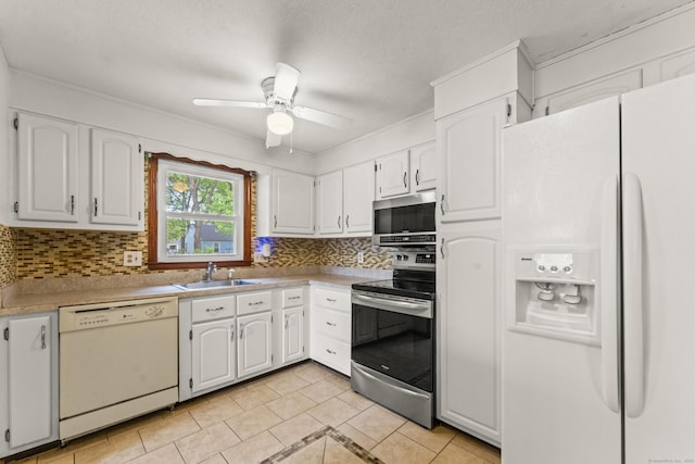 130 Jefferson Ln, East Hartford, CT 06118 - kitchen featuring appliances with stainless steel finishes, a sink, backsplash, light tile patterned floors, and white cabinetry