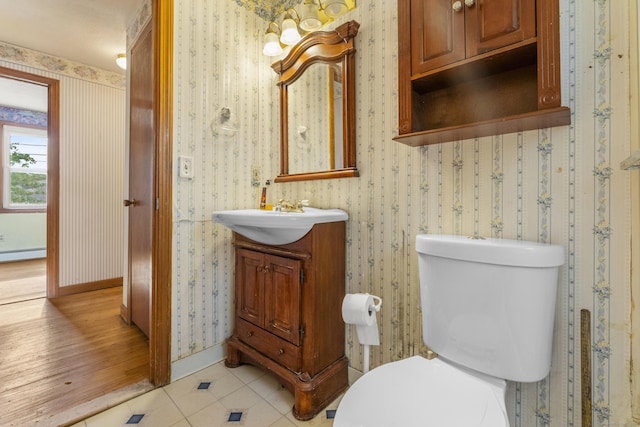 130 Jefferson Ln, East Hartford, CT 06118 - half bathroom featuring vanity, toilet, tile patterned flooring, wallpapered walls, and baseboards