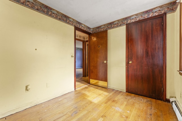 130 Jefferson Ln, East Hartford, CT 06118 - unfurnished bedroom with baseboard heating, light wood-style flooring, a closet, and baseboards