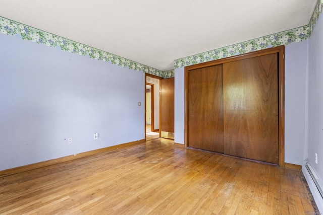 130 Jefferson Ln, East Hartford, CT 06118 - unfurnished bedroom with baseboard heating, light wood finished floors, a closet, and baseboards