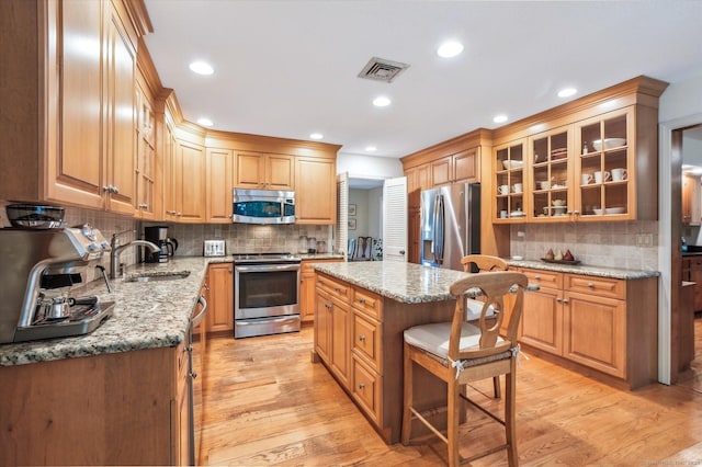 33 Cold Spring Rd, Avon, CT 06001 - kitchen with stainless steel appliances, backsplash, light wood-style floors, a sink, and light stone counters