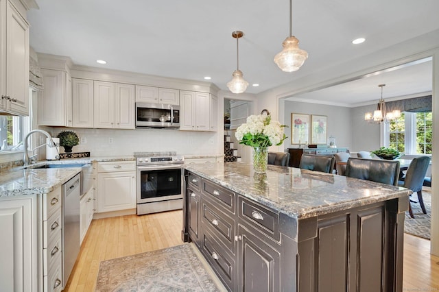 15 Stony Cors, Avon, CT 06001 - kitchen with appliances with stainless steel finishes, a chandelier, light wood finished floors, backsplash, and crown molding