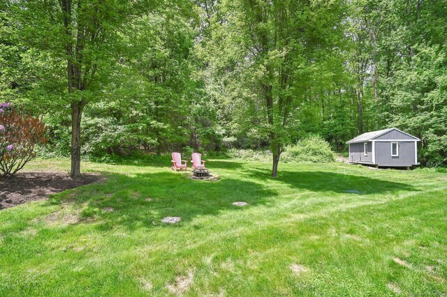 15 Stony Cors, Avon, CT 06001 - view of grassy yard featuring an outdoor fire pit and a view of trees