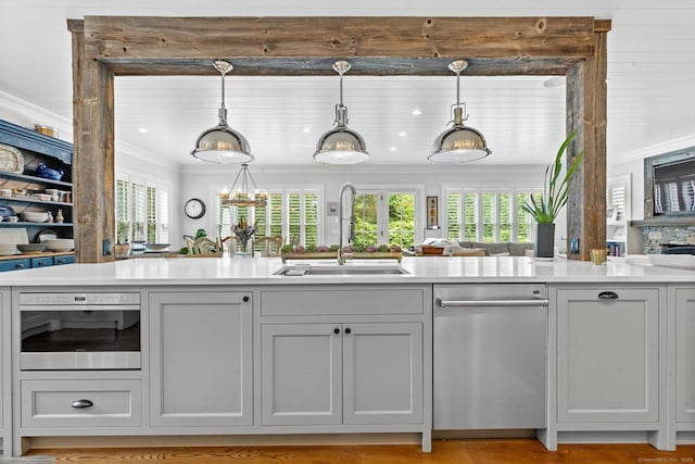 5 Oakleigh Ct, Norwalk, CT 06853 - kitchen featuring stainless steel appliances, a sink, ornamental molding, light countertops, and decorative light fixtures