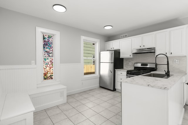 17 May St, Ansonia, CT 06401 - kitchen featuring stainless steel appliances, under cabinet range hood, a peninsula, wainscoting, and white cabinetry