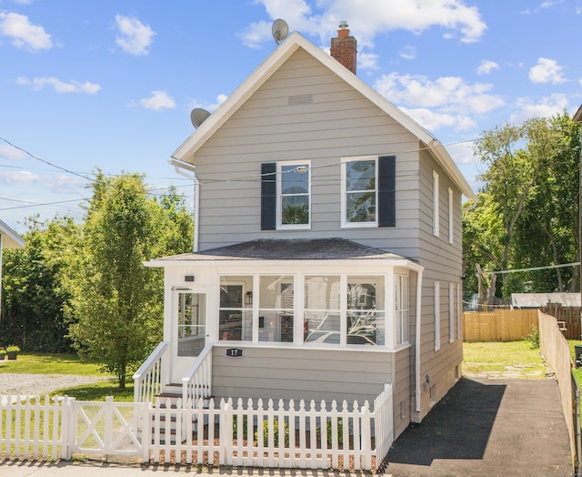 17 May St, Ansonia, CT 06401 - view of front of home with a fenced front yard, a chimney, a shingled roof, and a sunroom