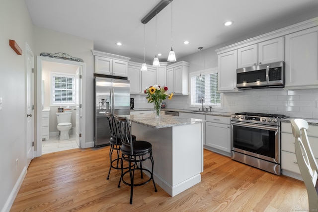 100 Silver Island Way Unit 100, Berlin, CT 06037 - kitchen with appliances with stainless steel finishes, a sink, a kitchen bar, tasteful backsplash, and a center island