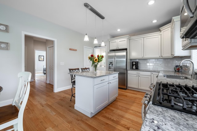 100 Silver Island Way Unit 100, Berlin, CT 06037 - kitchen featuring stainless steel appliances, a center island, tasteful backsplash, a sink, and white cabinetry