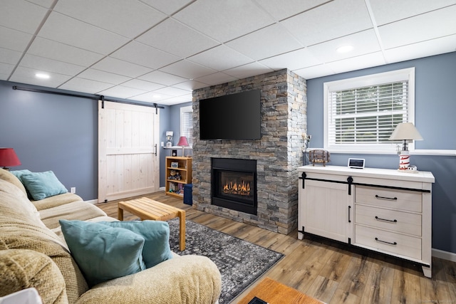 100 Silver Island Way Unit 100, Berlin, CT 06037 - living room featuring a barn door, wood finished floors, baseboards, a drop ceiling, and a fireplace