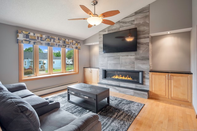 8 Lindsley St, Waterbury, CT 06708 - living area with baseboard heating, vaulted ceiling, a ceiling fan, a fireplace, and light wood-style flooring