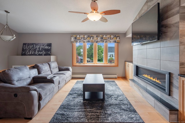 8 Lindsley St, Waterbury, CT 06708 - living room with a tile fireplace, light wood-style floors, ceiling fan, and baseboard heating