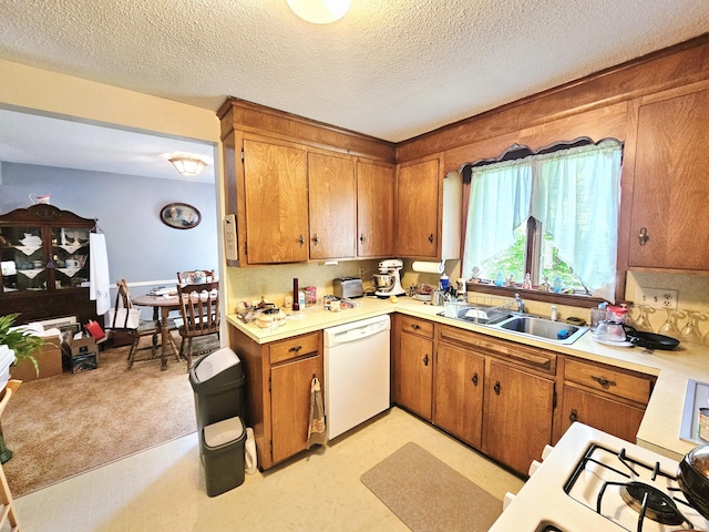 100 Morin Ave, Killingly, CT 06239 - kitchen featuring white dishwasher, a sink, light countertops, brown cabinets, and a textured ceiling