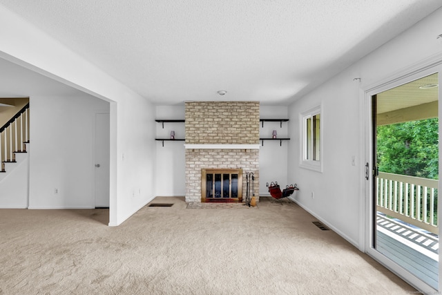 207 Summer Hill Dr Unit 207, South Windsor, CT 06074 - unfurnished living room with carpet, a brick fireplace, stairway, and a textured ceiling
