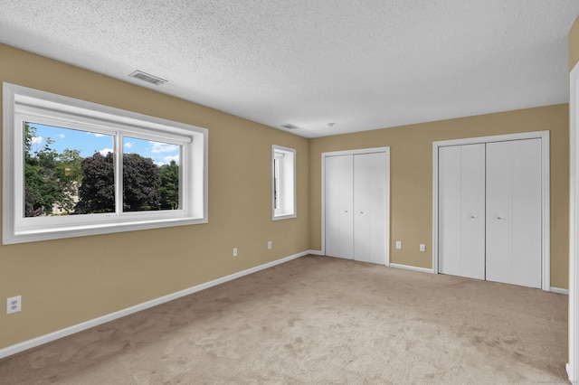 207 Summer Hill Dr Unit 207, South Windsor, CT 06074 - unfurnished bedroom featuring multiple windows, multiple closets, carpet floors, and a textured ceiling