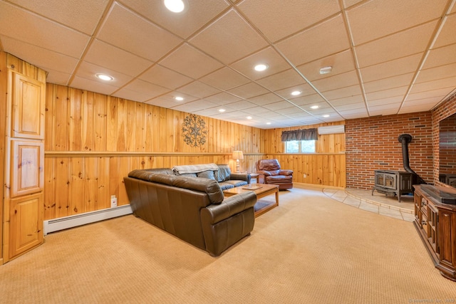 169 Dunn Rd, Coventry, CT 06238 - living room with a baseboard heating unit, wood walls, light carpet, a wood stove, and a paneled ceiling
