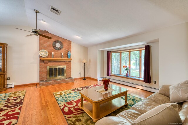 169 Dunn Rd, Coventry, CT 06238 - living area with a baseboard radiator, lofted ceiling, ceiling fan, wood finished floors, and a brick fireplace