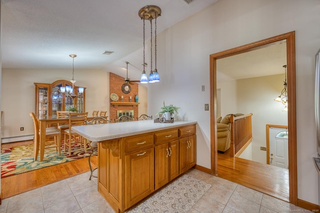 169 Dunn Rd, Coventry, CT 06238 - kitchen with baseboard heating, light tile patterned flooring, light countertops, lofted ceiling, and decorative light fixtures