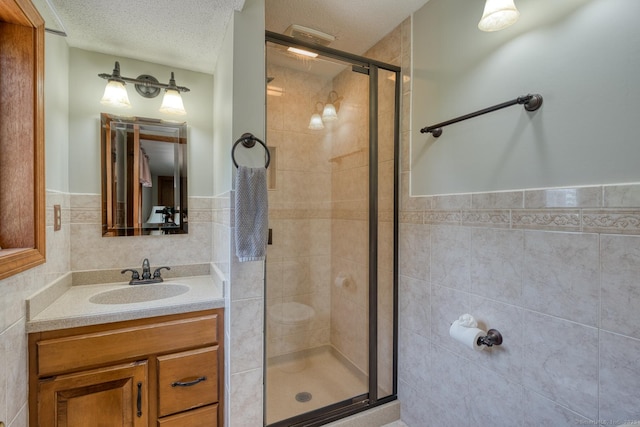 169 Dunn Rd, Coventry, CT 06238 - bathroom with tile walls, a stall shower, vanity, a textured ceiling, and wainscoting