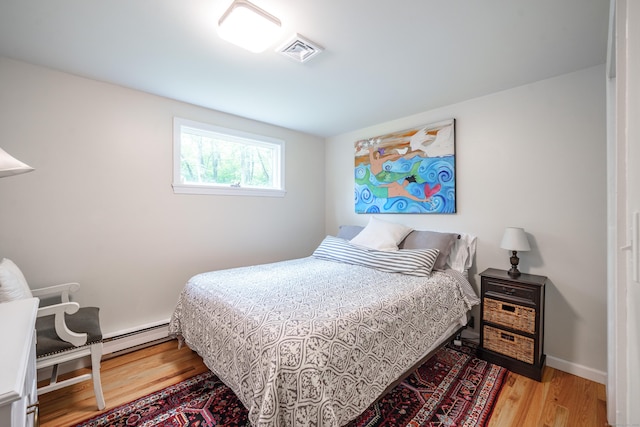211 Brainard Rd, Enfield, CT 06082 - bedroom featuring wood finished floors and a baseboard heating unit