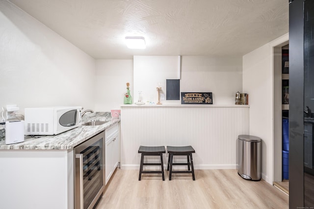 211 Brainard Rd, Enfield, CT 06082 - indoor wet bar with wine cooler, white microwave, light wood finished floors, and a textured ceiling
