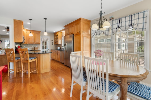 26 Parkway S, New London, CT 06320 - kitchen featuring appliances with stainless steel finishes, dark countertops, a chandelier, light wood-style flooring, and a peninsula