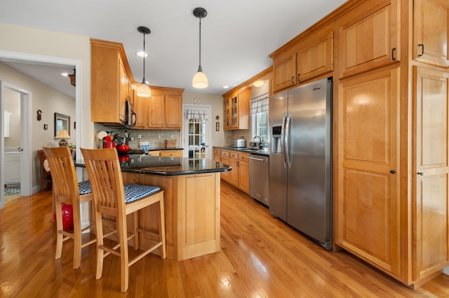26 Parkway S, New London, CT 06320 - kitchen featuring appliances with stainless steel finishes, a sink, dark countertops, light wood finished floors, and decorative backsplash