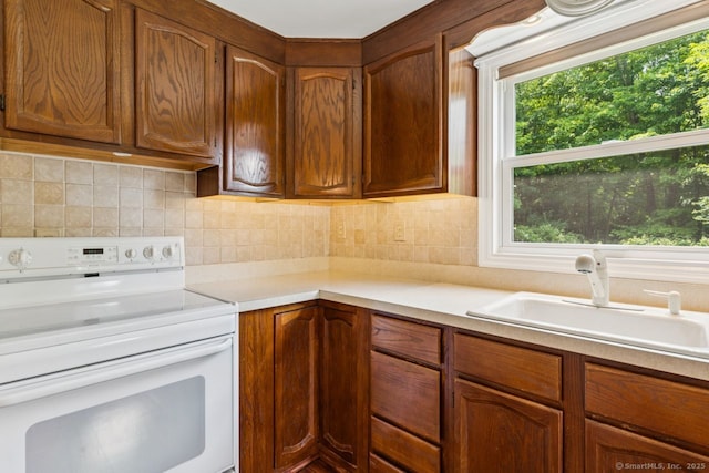 4 Buttonball Dr, Newtown, CT 06482 - kitchen with white range with electric stovetop, light countertops, decorative backsplash, and brown cabinetry
