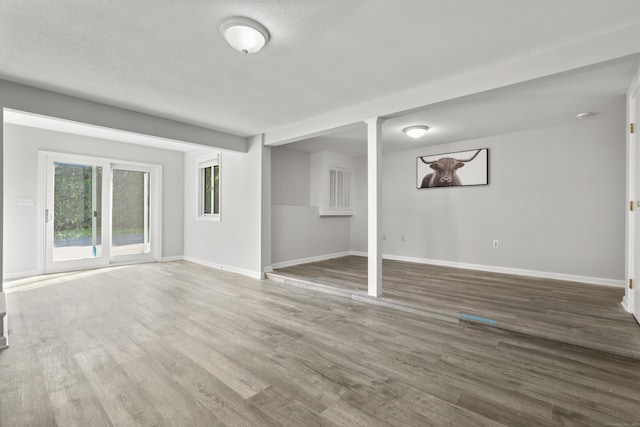 13 Williams Ct, Wolcott, CT 06716 - unfurnished living room with baseboards, wood finished floors, ornate columns, and a textured ceiling