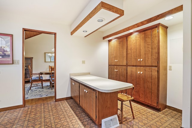 30 Bartling Dr, Easton, CT 06612 - kitchen featuring a peninsula, light countertops, brown cabinets, a kitchen breakfast bar, and baseboards