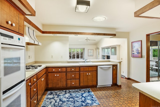 30 Bartling Dr, Easton, CT 06612 - kitchen with white appliances, a sink, light countertops, a peninsula, and brown cabinetry