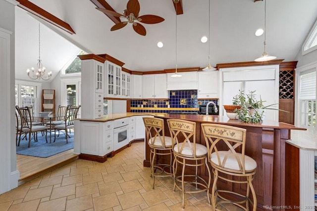 132 Old N Stamford Rd, Stamford, CT 06905 - kitchen featuring ceiling fan, oven, high vaulted ceiling, tasteful backsplash, and glass insert cabinets