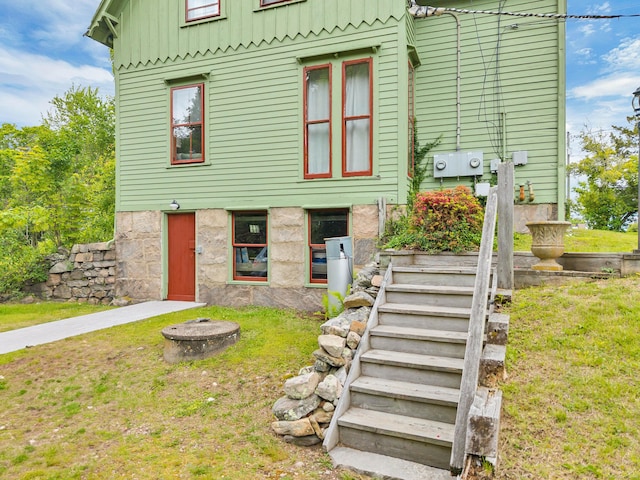 187 Whitehall Ave, Stonington, CT 06355 - view of front of house with board and batten siding, an outdoor fire pit, stairway, and a front yard
