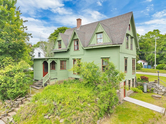 187 Whitehall Ave, Stonington, CT 06355 - victorian-style house featuring board and batten siding, a chimney, roof with shingles, a front lawn, and an attached garage