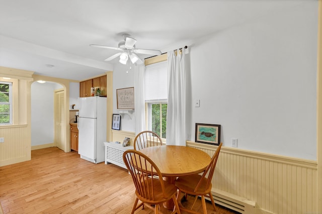187 Whitehall Ave, Stonington, CT 06355 - dining space with wainscoting, ceiling fan, light wood finished floors, and arched walkways