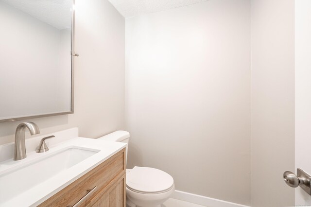 239 Old Farms Rd Apt 15B, Avon, CT 06001 - half bathroom with toilet, vanity, a textured ceiling, and baseboards