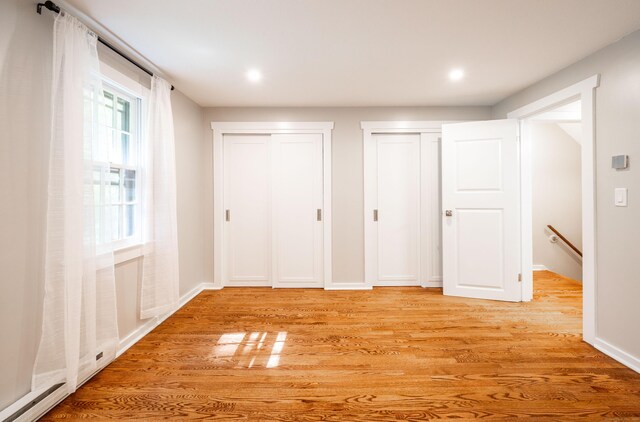239 Old Farms Rd Apt 15B, Avon, CT 06001 - unfurnished bedroom with multiple closets, light wood-style floors, baseboards, and recessed lighting