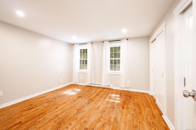 239 Old Farms Rd Apt 15B, Avon, CT 06001 - spare room featuring a baseboard radiator, light wood finished floors, baseboards, and recessed lighting