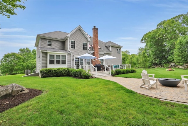 2 Lake Louise Dr, Westbrook, CT 06498 - back of property with a patio, an outdoor fire pit, a deck, a chimney, and a yard