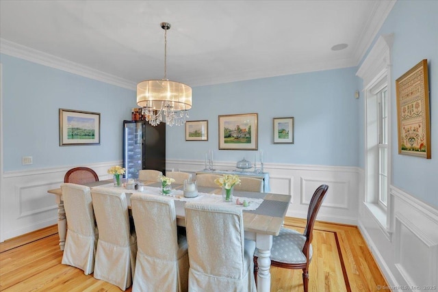 2 Lake Louise Dr, Westbrook, CT 06498 - dining area with light wood-type flooring, a chandelier, wainscoting, crown molding, and a decorative wall