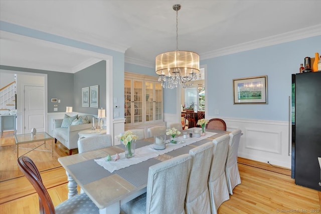 2 Lake Louise Dr, Westbrook, CT 06498 - dining space with a chandelier, light wood-type flooring, stairs, crown molding, and a wainscoted wall
