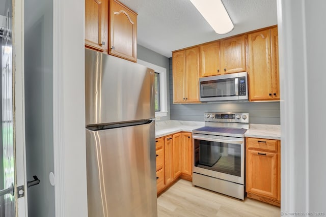 2 Edgehill Ct Unit 2, Woodbury, CT 06798 - kitchen featuring appliances with stainless steel finishes, light countertops, light wood-style flooring, and a textured ceiling