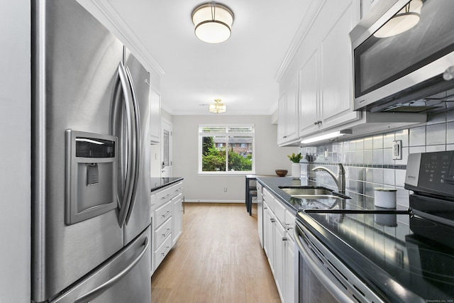 116 Southport Woods Dr, Fairfield, CT 06890 - kitchen with stainless steel appliances, a sink, white cabinetry, crown molding, and light wood-style floors